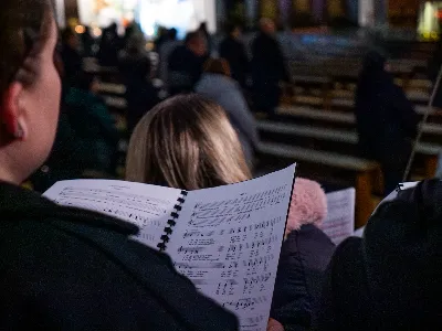 „Zaiste, godna jesteś, Matko, wszelkiej chwały, któraś między wszystkimi świętymi Najświętsze zrodziła Słowo. Od przyszłej kary wybaw nas, którzy pospołu do Ciebie wołamy: Alleluja”. Tymi słowami wychwalali Matkę Bożą zgromadzeni w rzeszowskiej katedrze w wigilię jednej z najważniejszych uroczystości w Kościele – uroczystości Niepokalanego Poczęcia Najświętszej Maryi Panny. W tym szczególnym dniu miało miejsce nabożeństwo Akatystu ku czci Bogurodzicy – jednego z najstarszych hymnów liturgicznych wychwalających Najświętszą Maryję Pannę.

Nabożeństwo zyskało szczególną rangę, gdyż wraz z wiernymi modlił się także Biskup Rzeszowski Jan Wątroba, co podkreślało doniosłość tego wydarzenia dla katedralnej wspólnoty.

Historia Akatystu sięga V wieku, a jego autorstwo przypisuje się świętemu Romanowi Pieśniarzowi. Według tradycji, święty otrzymał hymn w niezwykły sposób – miał się mu objawić we śnie Niebiański Wysłannik i wręczyć zwój z tekstem. Rankiem święty Roman wyśpiewał jego treść, a hymn ten przez wieki rozbrzmiewa ku czci Bogurodzicy. Według jednej z podań historycznych, Akatyst został po raz pierwszy wykonany 7 sierpnia 626 roku, gdy – za wstawiennictwem Maryi – miasto Konstantynopol zostało cudownie uratowane przed najazdem. Wtedy też mieszkańcy śpiewali hymn całą noc, stojąc na znak wdzięczności i czci.

Choć Akatyst wywodzi się z tradycji bizantyńskiej i jest ściśle związany z liturgią wschodnią, już w VIII wieku został przetłumaczony na łacinę, a później na wiele języków narodowych. W ten sposób trafił także do praktyki liturgicznej Kościoła Zachodniego. Współcześnie jest odmawiany i śpiewany w wielu kościołach w Polsce – zwłaszcza przy okazji uroczystości maryjnych, takich jak 8 grudnia (Niepokalane Poczęcie NMP) czy 25 marca (Zwiastowanie NMP).

Akatyst składa się z 24 zwrotek, które ułożone są według kolejnych liter alfabetu. Każda strofa wprowadza głęboką refleksję nad tajemnicą Wcielenia Słowa i rolą Maryi w planie zbawienia. Niezwykłym elementem tej modlitwy jest fakt, że każda dłuższa strofa rozpoczyna się uroczystym „Witaj”, a kończy wezwaniem „Witaj Oblubienico Dziewicza”. Ze względu na greckie znaczenie słowa akathistos („nie siedzący”), hymn wykonuje się na stojąco.

W przeddzień uroczystości Niepokalanego Poczęcia NMP wierni licznie zgromadzili się w rzeszowskiej katedrze, by wspólnie uwielbiać Tę, która została zachowana od zmazy pierworodnej. Wprowadzenia w modlitwę Akatystu dokonał ks. Julian Wybraniec, przypominając historię tego starożytnego nabożeństwa i objaśniając jego strukturę. Po uroczystej procesji wejścia, przy figurze Matki Bożej Fatimskiej, rozpoczęto modlitwę wezwaniem „O Waleczna Hetmanko”. Nabożeństwu przewodniczył ks. Karol Migut, wikariusz katedralny, a trzygłosowy śpiew poprowadziła Katedralna Schola Liturgiczna pod dyrekcją ks. Juliana Wybrańca.

Wyjątkowy klimat tej modlitwy podkreślały elementy pełne symboliki – figura Matki Bożej wielokrotnie okadzana, światła w świątyni niemal całkowicie zgaszone, a jedynym światłem stały się zapalone świece trzymane w dłoniach wiernych. Nabożeństwo zakończyło się uroczystym błogosławieństwem i rozesłaniem.

Bogactwo duchowe i teologiczne Akatystu pozwoliło uczestnikom nie tylko przygotować się do uroczystości Niepokalanego Poczęcia, ale także pogłębić refleksję nad rolą Maryi w Boskim planie zbawienia. Wyszeptane i uniesione modlitwy pomogły wiernym dostrzec, że Maryja jest Przewodniczką na drodze przygotowania do przyjścia Zbawiciela – zarówno w nadchodzącego Bożego Narodzenia, jak i w oczekiwanym powtórnym przyjściu Chrystusa na ziemię.

Niech ta modlitwa, odwieczna w swojej treści i dziś odżywająca przez wspólne uczestnictwo, pogłębi w nas wiarę, nadzieję i miłość – zwłaszcza w czasie Adwentu.

Angelika Karnasiewicz, fot. Antoni Ważny