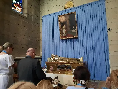 Śladami kultu Najświętszego Serca Pana Jezusa 
Jubileuszowa pielgrzymka do Francji – 9–15 czerwca 2025 r. 

W dniach 9–15 czerwca br. odbyła się jubileuszowa pielgrzymka parafii katedralnej Najświętszego Serca Pana Jezusa do Francji – ojczyzny wielu świętych oraz miejsc głęboko związanych z kultem Najświętszego Serca Pana Jezusa. Nasze pielgrzymowanie wpisywało się w obchody Roku Jubileuszowego ogłoszonego przez papieża Franciszka pod hasłem „Pielgrzymi Nadziei”, a także w kontekst kilku ważnych rocznic: 350-lecia objawień Jezusa św. Marii Małgorzacie Alacoque, 100-lecia beatyfikacji św. Bernadetty Soubirous oraz 100-lecia kanonizacji św. Teresy z Lisieux i św. Jana Marii Vianney.

Pierwszym punktem pielgrzymki było Ars – miejsce życia i posługi św. Jana Marii Vianney, patrona proboszczów. W sanktuarium tego wielkiego świętego uczestniczyliśmy we Mszy Świętej przy jego relikwiarzu, prosząc o dar gorliwości kapłańskiej i wierności powołaniu. Odwiedziliśmy również Muzeum Figur Woskowych, które przybliżyło nam życie Świętego Proboszcza z Ars.

Kolejnego dnia dotarliśmy do Paray-le-Monial – miejsca objawień Najświętszego Serca Jezusowego św. Marii Małgorzacie Alacoque. W bazylice Sacré-Cœur uczestniczyliśmy we Mszy Świętej, zawierzając Sercu Jezusa nasze osobiste intencje oraz całą wspólnotę parafialną. Następnie nawiedziliśmy Nevers, gdzie znajduje się ciało św. Bernadetty spoczywające w szklanym relikwiarzu. Był to czas ciszy, modlitwy i refleksji nad jej pokorą i prostotą.

W środę modliliśmy się przy grobie św. Marcina z Tours, a następnie udaliśmy się szlakiem zamków nad Loarą. Zwiedziliśmy między innymi zamek Chenonceau zbudowany na wodzie, zamek Amboise, w którym przebywał Leonardo da Vinci, oraz imponujący Chambord – perełkę francuskiego renesansu.

Czwartek poświęciliśmy na odkrywanie duchowego i kulturalnego bogactwa Paryża. Rozpoczęliśmy od wjazdu na wieżę Eiffla, a następnie nawiedziliśmy katedrę Notre Dame oraz kaplicę Cudownego Medalika z relikwiami św. Katarzyny Labouré. Najważniejszym punktem dnia była uroczysta Msza Święta w bazylice Sacré-Cœur na wzgórzu Montmartre. Wieczorem odbyliśmy rejs po Sekwanie, podziwiając oświetlone zabytki stolicy Francji. Każdego dnia towarzyszyły nam również lokalne smaki – francuskie pieczywo, wypieki, desery, a dla chętnych – regionalne specjały, takie jak ślimaki.

W piątek dotarliśmy do Lisieux – miasta św. Teresy od Dzieciątka Jezus. Odwiedziliśmy jej dom rodzinny Le Bissonnets, klasztor karmelitanek oraz bazylikę jej poświęconą. Msza Święta w tym miejscu była wyjątkowym momentem zawierzenia oraz duchowego spotkania z „małą drogą” św. Teresy.

W drodze powrotnej nawiedziliśmy jeszcze stolicę Belgii – Brukselę. W bazylice Najświętszego Serca Jezusa sprawowaliśmy Eucharystię, a następnie spacerowaliśmy po starówce oraz dzielnicy europejskiej. Ostatnia Msza Święta była dziękczynieniem za dar pielgrzymowania i wszelkie łaski, których doświadczyliśmy podczas tych dni.

Naszej pielgrzymce codziennie towarzyszyła modlitwa litanią do Najświętszego Serca Pana Jezusa oraz różaniec. Był to czas duchowego wzrostu, wspólnoty, modlitwy, zachwytu nad pięknem stworzenia i wdzięczności za dziedzictwo wiary.

Wdzięczni uczestnicy pielgrzymki