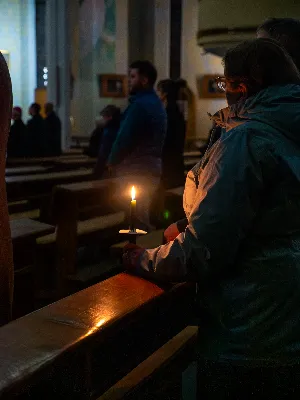„Zaiste, godna jesteś, Matko, wszelkiej chwały, któraś między wszystkimi świętymi Najświętsze zrodziła Słowo. Od przyszłej kary wybaw nas, którzy pospołu do Ciebie wołamy: Alleluja”. Tymi słowami wychwalali Matkę Bożą zgromadzeni w rzeszowskiej katedrze w wigilię jednej z najważniejszych uroczystości w Kościele – uroczystości Niepokalanego Poczęcia Najświętszej Maryi Panny. W tym szczególnym dniu miało miejsce nabożeństwo Akatystu ku czci Bogurodzicy – jednego z najstarszych hymnów liturgicznych wychwalających Najświętszą Maryję Pannę.

Nabożeństwo zyskało szczególną rangę, gdyż wraz z wiernymi modlił się także Biskup Rzeszowski Jan Wątroba, co podkreślało doniosłość tego wydarzenia dla katedralnej wspólnoty.

Historia Akatystu sięga V wieku, a jego autorstwo przypisuje się świętemu Romanowi Pieśniarzowi. Według tradycji, święty otrzymał hymn w niezwykły sposób – miał się mu objawić we śnie Niebiański Wysłannik i wręczyć zwój z tekstem. Rankiem święty Roman wyśpiewał jego treść, a hymn ten przez wieki rozbrzmiewa ku czci Bogurodzicy. Według jednej z podań historycznych, Akatyst został po raz pierwszy wykonany 7 sierpnia 626 roku, gdy – za wstawiennictwem Maryi – miasto Konstantynopol zostało cudownie uratowane przed najazdem. Wtedy też mieszkańcy śpiewali hymn całą noc, stojąc na znak wdzięczności i czci.

Choć Akatyst wywodzi się z tradycji bizantyńskiej i jest ściśle związany z liturgią wschodnią, już w VIII wieku został przetłumaczony na łacinę, a później na wiele języków narodowych. W ten sposób trafił także do praktyki liturgicznej Kościoła Zachodniego. Współcześnie jest odmawiany i śpiewany w wielu kościołach w Polsce – zwłaszcza przy okazji uroczystości maryjnych, takich jak 8 grudnia (Niepokalane Poczęcie NMP) czy 25 marca (Zwiastowanie NMP).

Akatyst składa się z 24 zwrotek, które ułożone są według kolejnych liter alfabetu. Każda strofa wprowadza głęboką refleksję nad tajemnicą Wcielenia Słowa i rolą Maryi w planie zbawienia. Niezwykłym elementem tej modlitwy jest fakt, że każda dłuższa strofa rozpoczyna się uroczystym „Witaj”, a kończy wezwaniem „Witaj Oblubienico Dziewicza”. Ze względu na greckie znaczenie słowa akathistos („nie siedzący”), hymn wykonuje się na stojąco.

W przeddzień uroczystości Niepokalanego Poczęcia NMP wierni licznie zgromadzili się w rzeszowskiej katedrze, by wspólnie uwielbiać Tę, która została zachowana od zmazy pierworodnej. Wprowadzenia w modlitwę Akatystu dokonał ks. Julian Wybraniec, przypominając historię tego starożytnego nabożeństwa i objaśniając jego strukturę. Po uroczystej procesji wejścia, przy figurze Matki Bożej Fatimskiej, rozpoczęto modlitwę wezwaniem „O Waleczna Hetmanko”. Nabożeństwu przewodniczył ks. Karol Migut, wikariusz katedralny, a trzygłosowy śpiew poprowadziła Katedralna Schola Liturgiczna pod dyrekcją ks. Juliana Wybrańca.

Wyjątkowy klimat tej modlitwy podkreślały elementy pełne symboliki – figura Matki Bożej wielokrotnie okadzana, światła w świątyni niemal całkowicie zgaszone, a jedynym światłem stały się zapalone świece trzymane w dłoniach wiernych. Nabożeństwo zakończyło się uroczystym błogosławieństwem i rozesłaniem.

Bogactwo duchowe i teologiczne Akatystu pozwoliło uczestnikom nie tylko przygotować się do uroczystości Niepokalanego Poczęcia, ale także pogłębić refleksję nad rolą Maryi w Boskim planie zbawienia. Wyszeptane i uniesione modlitwy pomogły wiernym dostrzec, że Maryja jest Przewodniczką na drodze przygotowania do przyjścia Zbawiciela – zarówno w nadchodzącego Bożego Narodzenia, jak i w oczekiwanym powtórnym przyjściu Chrystusa na ziemię.

Niech ta modlitwa, odwieczna w swojej treści i dziś odżywająca przez wspólne uczestnictwo, pogłębi w nas wiarę, nadzieję i miłość – zwłaszcza w czasie Adwentu.

Angelika Karnasiewicz, fot. Antoni Ważny
